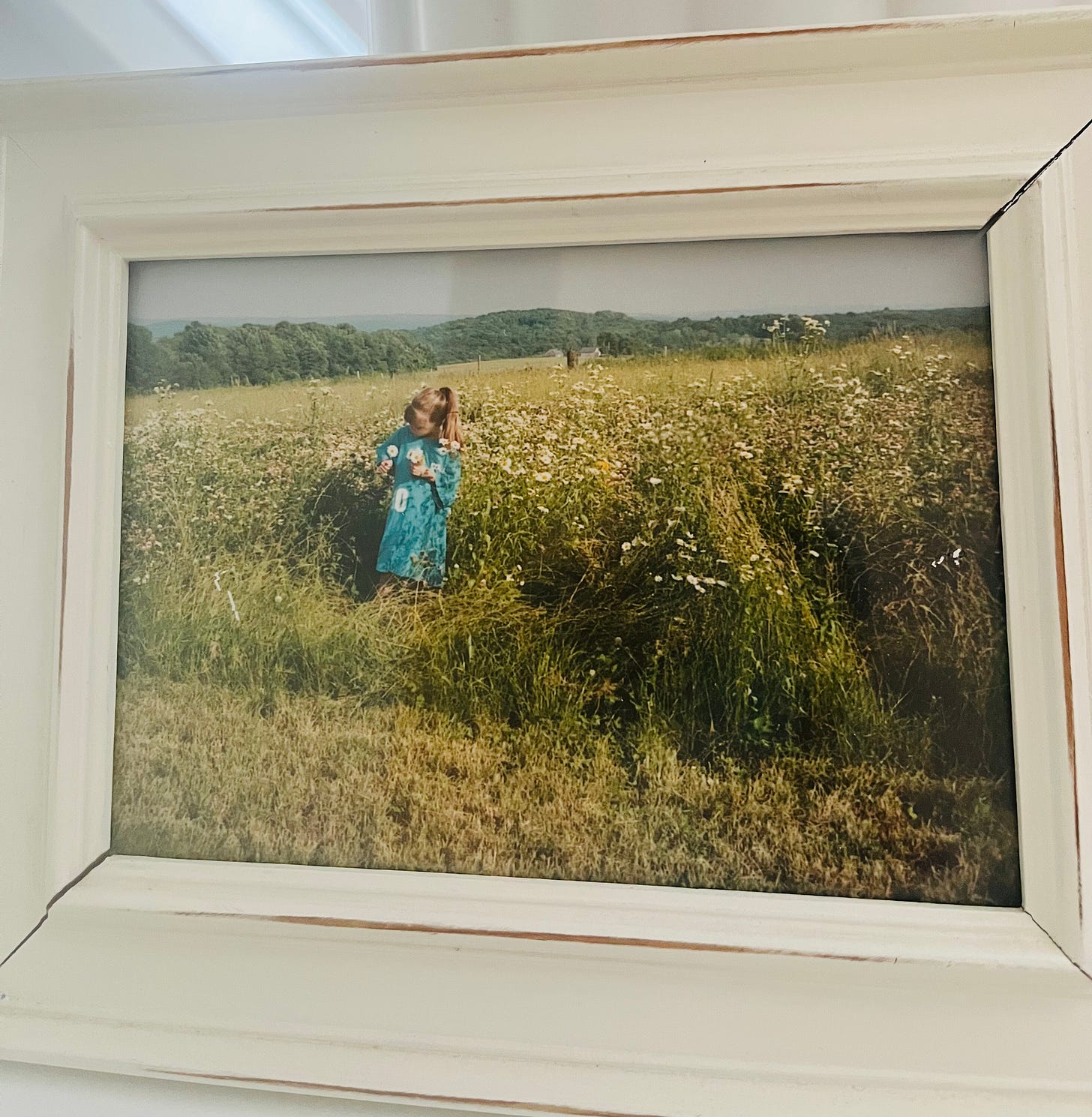 An image of SVB as a child, in a field, picking flowers.