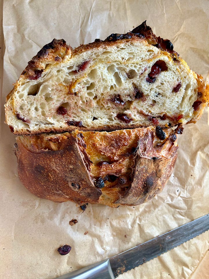Collage of sourdough loaves, featuring an overhead shot and crumb shot of a cinnamon raisin loaf and a cranberry, white chocolate, and orange sourdough loaf.