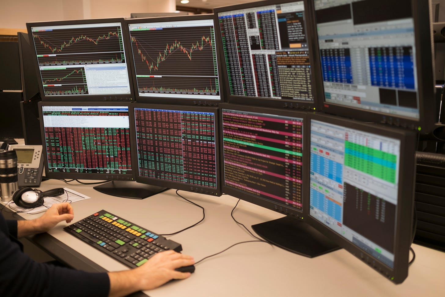 Abank of computer monitors with charts and graphs