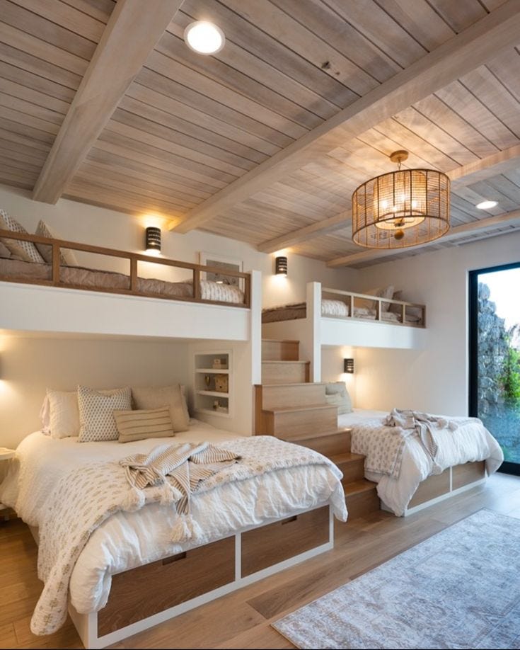 This may contain: two beds in a room with wooden floors and white walls, one is made up to look like a loft bed
