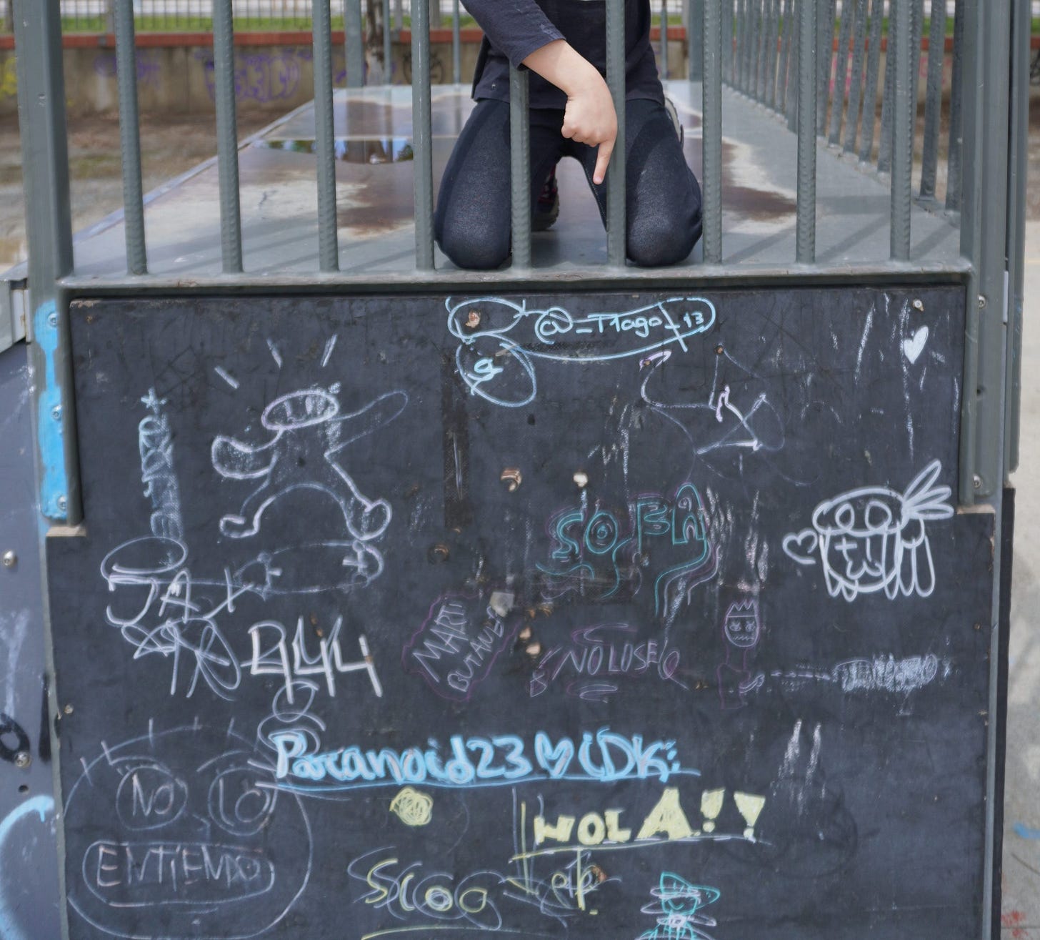 A young girl points down disapprovingly at graffiti in the skate park
