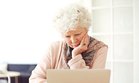 Woman at home reading something on her laptop