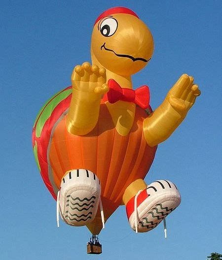 A hot air balloon shaped like a goofy turtle with sneakers, a hat, and bowtie.