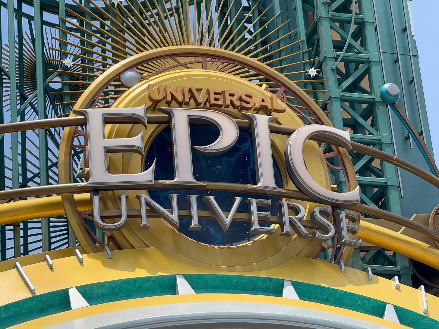 Sign reading "Universal Epic Universe" with celestial design and green metal framework at Epic Universe park.