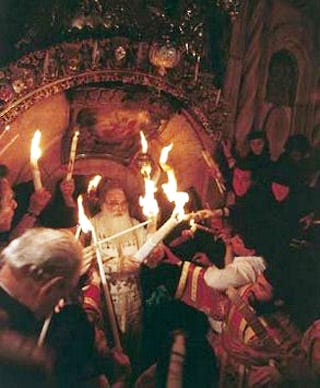 The Patriarch of Jerusalem brings out the Holy Fire from the shrine encasing the Tomb of Christ