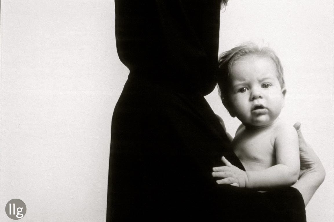 baby and caped person in black and white 