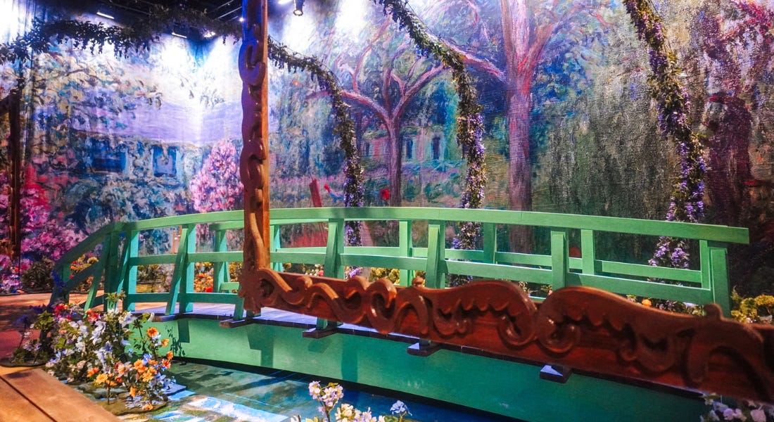 A green bridge with flowers and paintings around it A green bridge with flowers and paintings around it