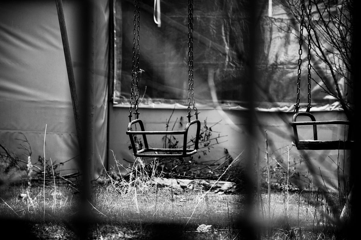 2 empty metal swings in black and white