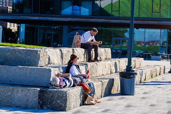 Four Seaport candids: people resting on granite blocks, a dock worker, a woman with her dog, and a woman at a table on the lawn