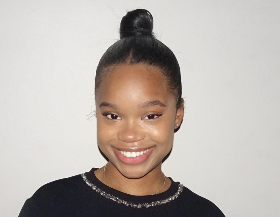 A person smiling at the camera

Description automatically generated