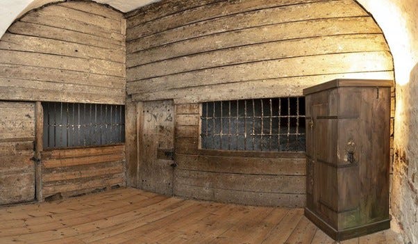 Two images showing cells at Colchester Castle. The first shows a wooden boarded room with cells on all sides. Cells have wooden doors and open barred windows. The second image shows the cell interior - wooden boarded stone rooms with silhouettes of prisoners projected on the wall.
