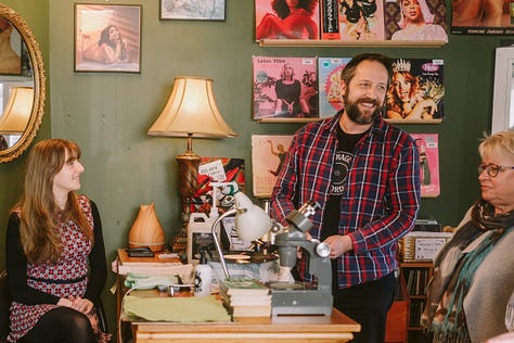 1 & 4 Oberon and Xanthe chat about preloved records with the local community. 2. Oberon shows an eco-vinyl record made from waste plastics in a carbon neutral process. 3. Oberon demonstrates his method of record repair, with a microscope. 5. Oberon shows a young visitor how to care for record players and how they work.