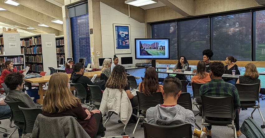 A group of people in a library, view from the audience
