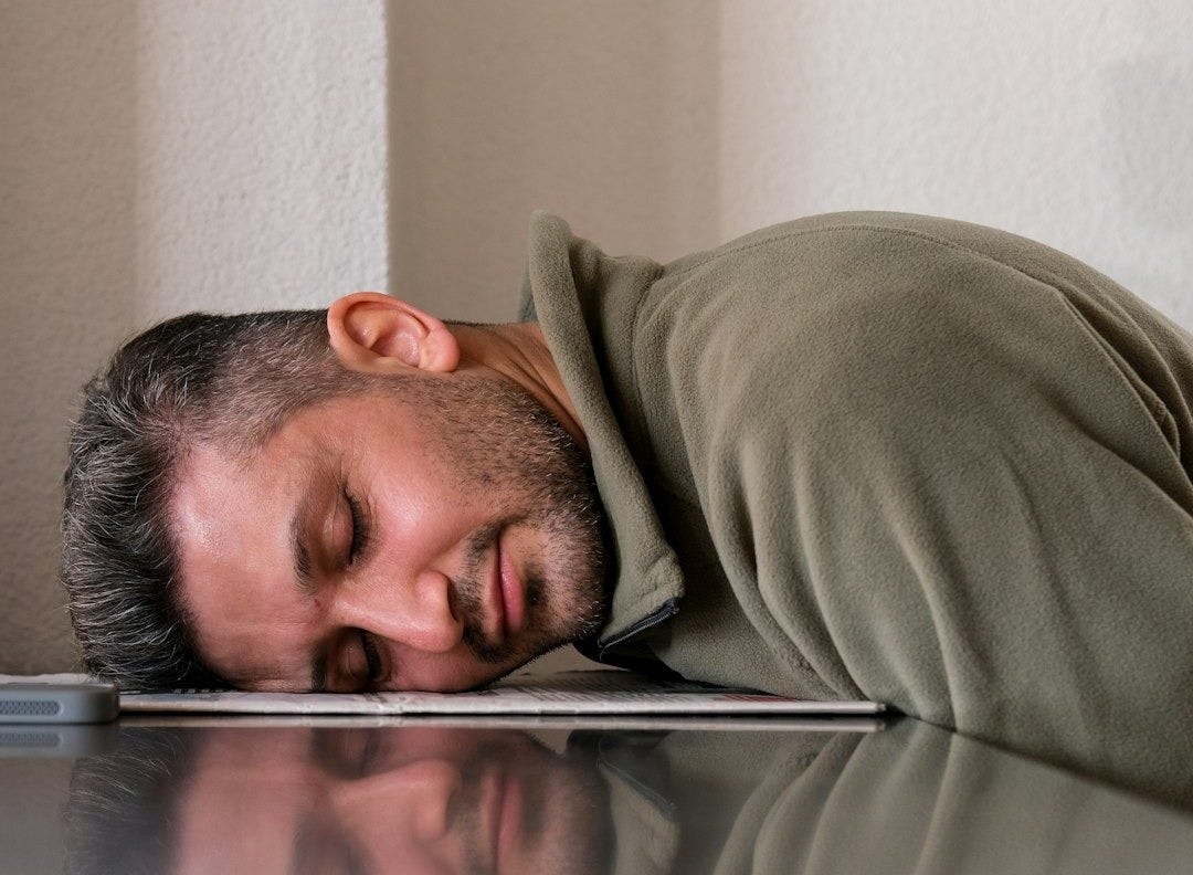 A man is sleeping on the floor with his head on a laptop A man is sleeping on the floor with his head on a laptop