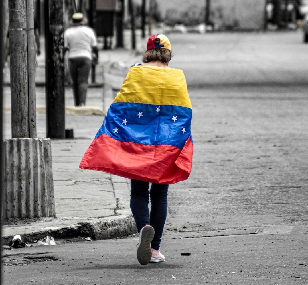 A person walking down a street holding a flag