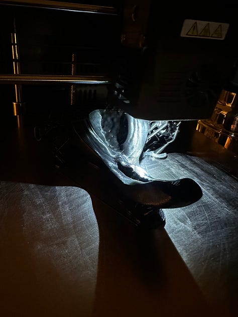 A custom 3D printer designed to look like solar punk, with black 3D printed anatomy models of reproductive organs.