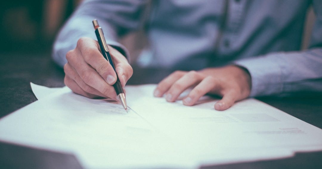 man writing on paper