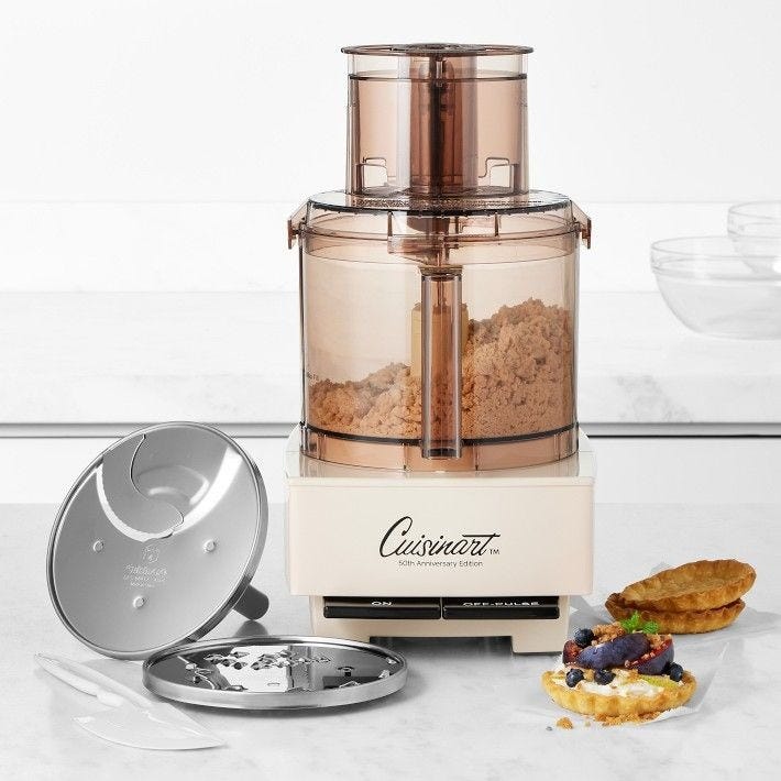 This may contain: a food processor sitting on top of a counter next to a plate with some pastries