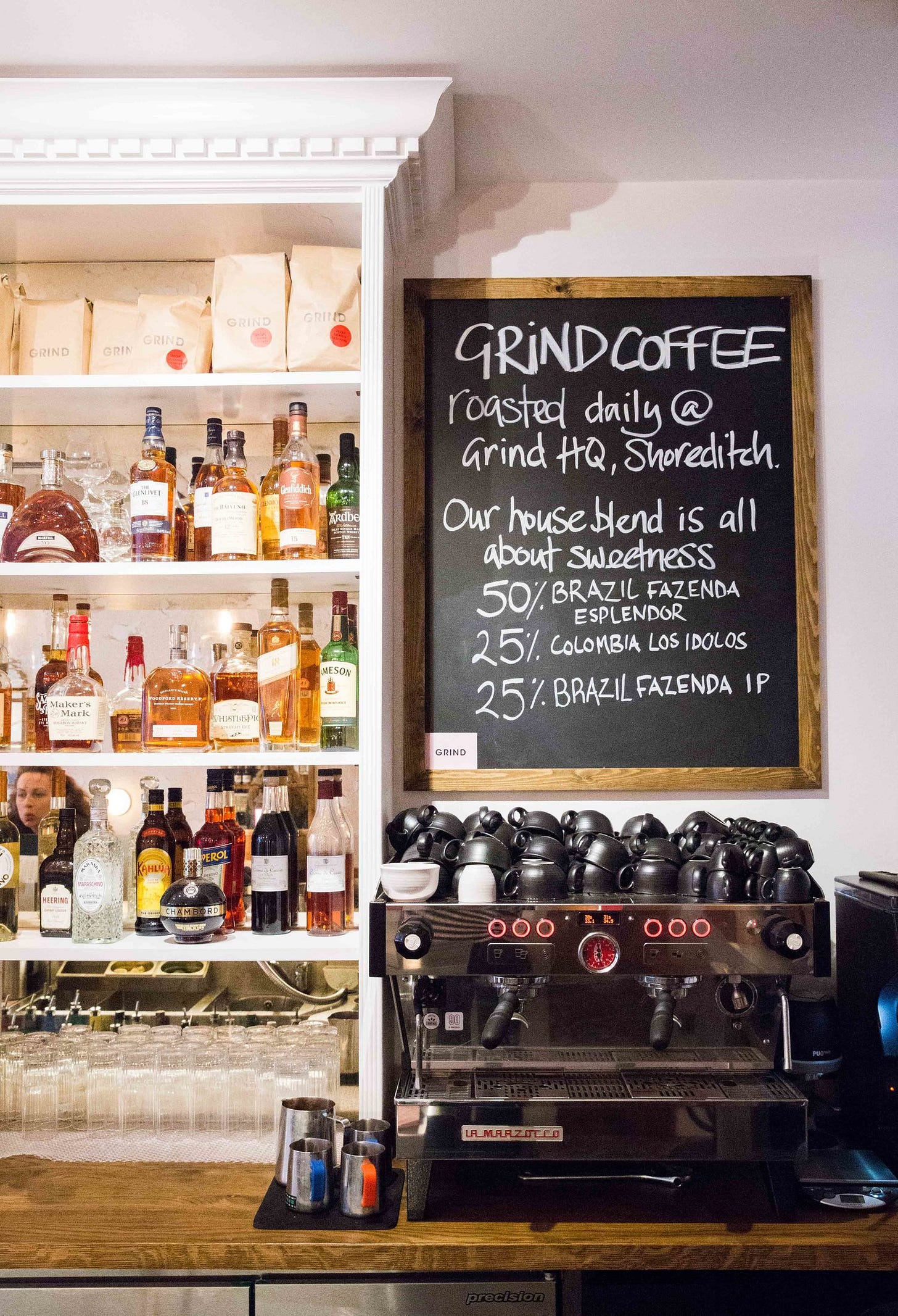Coffee cups sit upturned next to liquor bottles at 31 Below in Marylebone, London. 