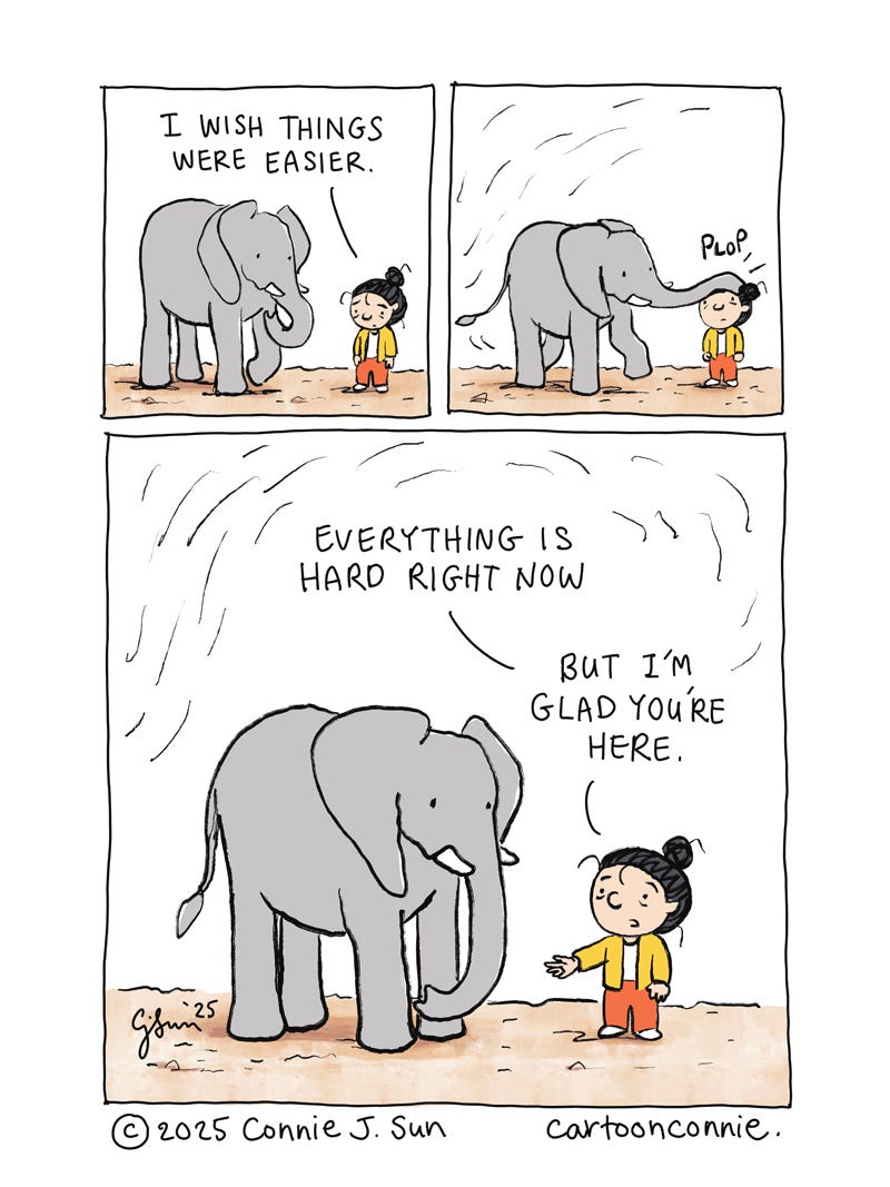 3-panel comic strip in simple colors, illustrating a girl with a bun talking to an elephant and wishing life were easier. The elephant responds by plopping its trunk on her head. In the last panel, the girl says, "Everything is hard right now, but I'm glad you're here." Titled "Glad You're Here," original artwork by Connie Sun, cartoonconnie, 2025. 3-panel comic strip in simple colors, illustrating a girl with a bun talking to an elephant and wishing life were easier. The elephant responds by plopping its trunk on her head. In the last panel, the girl says, "Everything is hard right now, but I'm glad you're here." Titled "Glad You're Here," original artwork by Connie Sun, cartoonconnie, 2025.