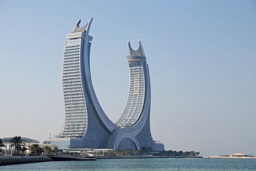 A view of a two-towered building shaped roughly in a semi-circle. A view of a two-towered building shaped roughly in a semi-circle.