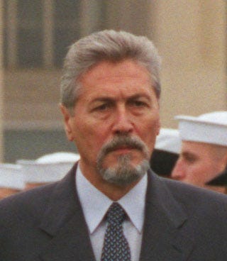 portrait of a goateed man in a suit