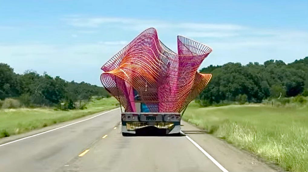 Steel sculpture traveling as an oversized load on a two-lane highway