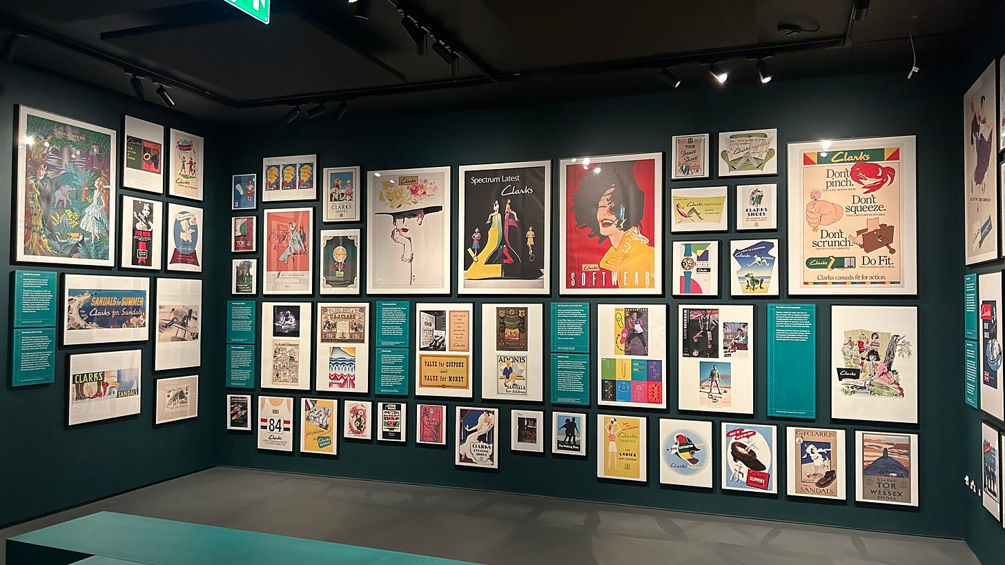 A wall of old advertising posters for Clarks Shoes at the Clarks Shoemakers Museum. A wall of old advertising posters for Clarks Shoes at the Clarks Shoemakers Museum.