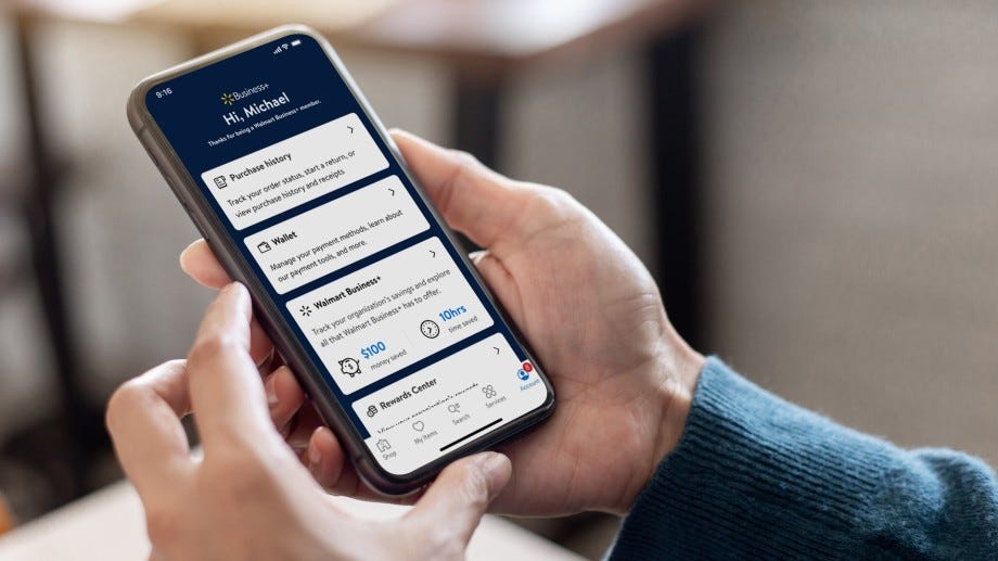 Hand holding mobile device with Walmart Business App