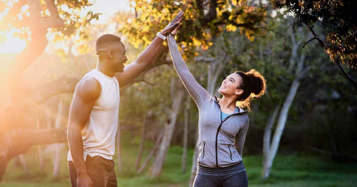 Man and woman stood outside high fiving 
