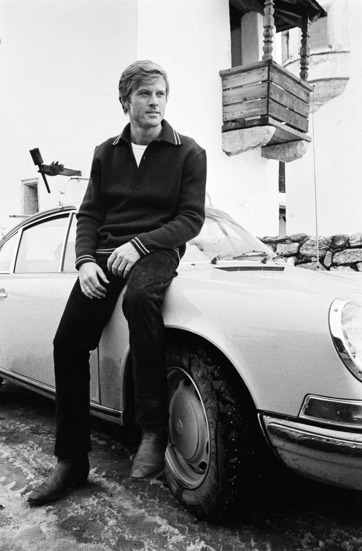 This may contain: a man sitting on the hood of a car