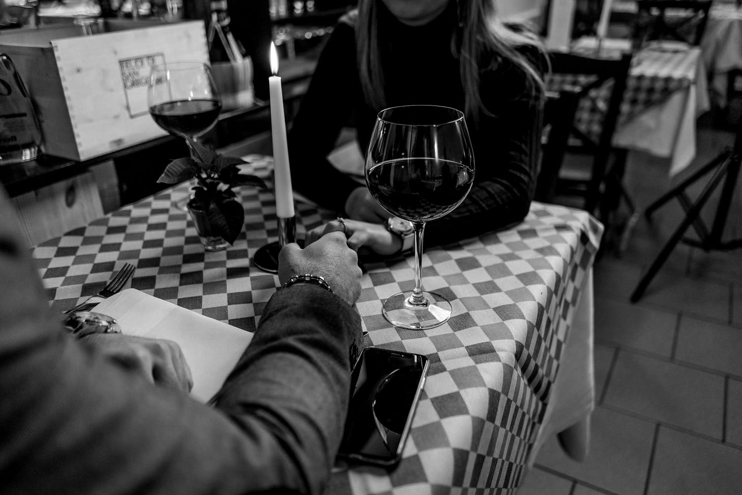 woman wearing black sweater holding hand with man wearing gray suit jacket woman wearing black sweater holding hand with man wearing gray suit jacket