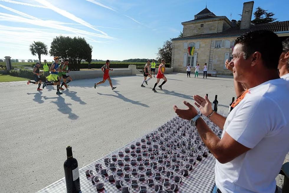 Runners gather at a wine tasting station during the Médoc Marathon, one of 23 stops where participants can sample local wines along the course. Runners gather at a wine tasting station during the Médoc Marathon, one of 23 stops where participants can sample local wines along the course.
