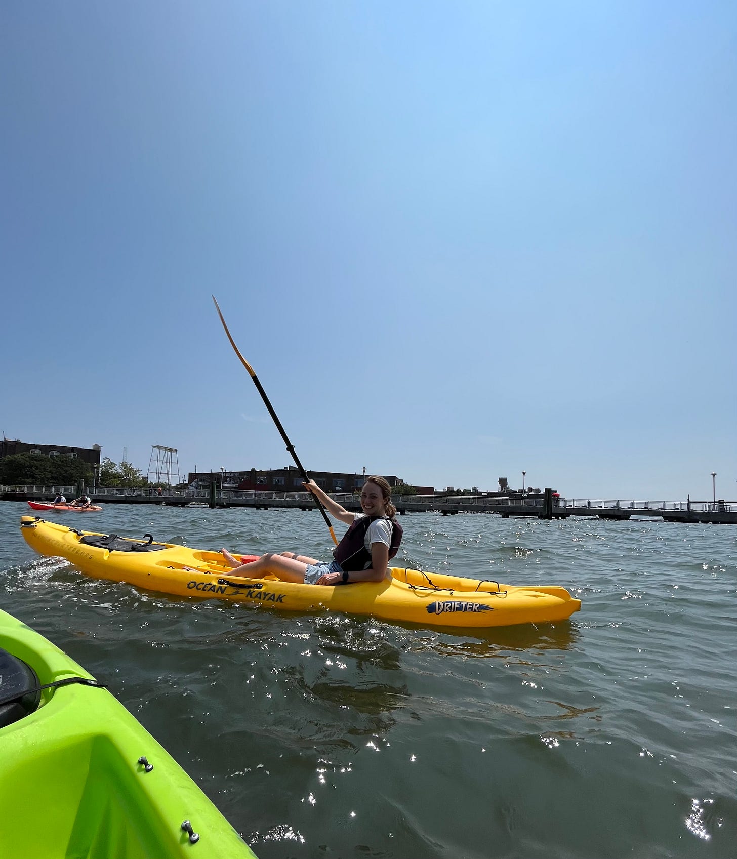 my friend hannah in a kayak on the hudson river holding up her oar