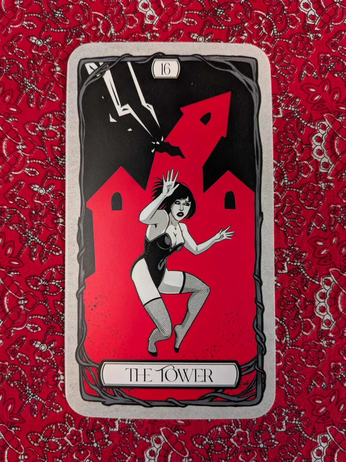 The Tower card from Michelle Lodge’s Bad Witch Tarot, showing a woman recoiling as lightning strikes a red tower. The Tower card from Michelle Lodge’s Bad Witch Tarot, showing a woman recoiling as lightning strikes a red tower.
