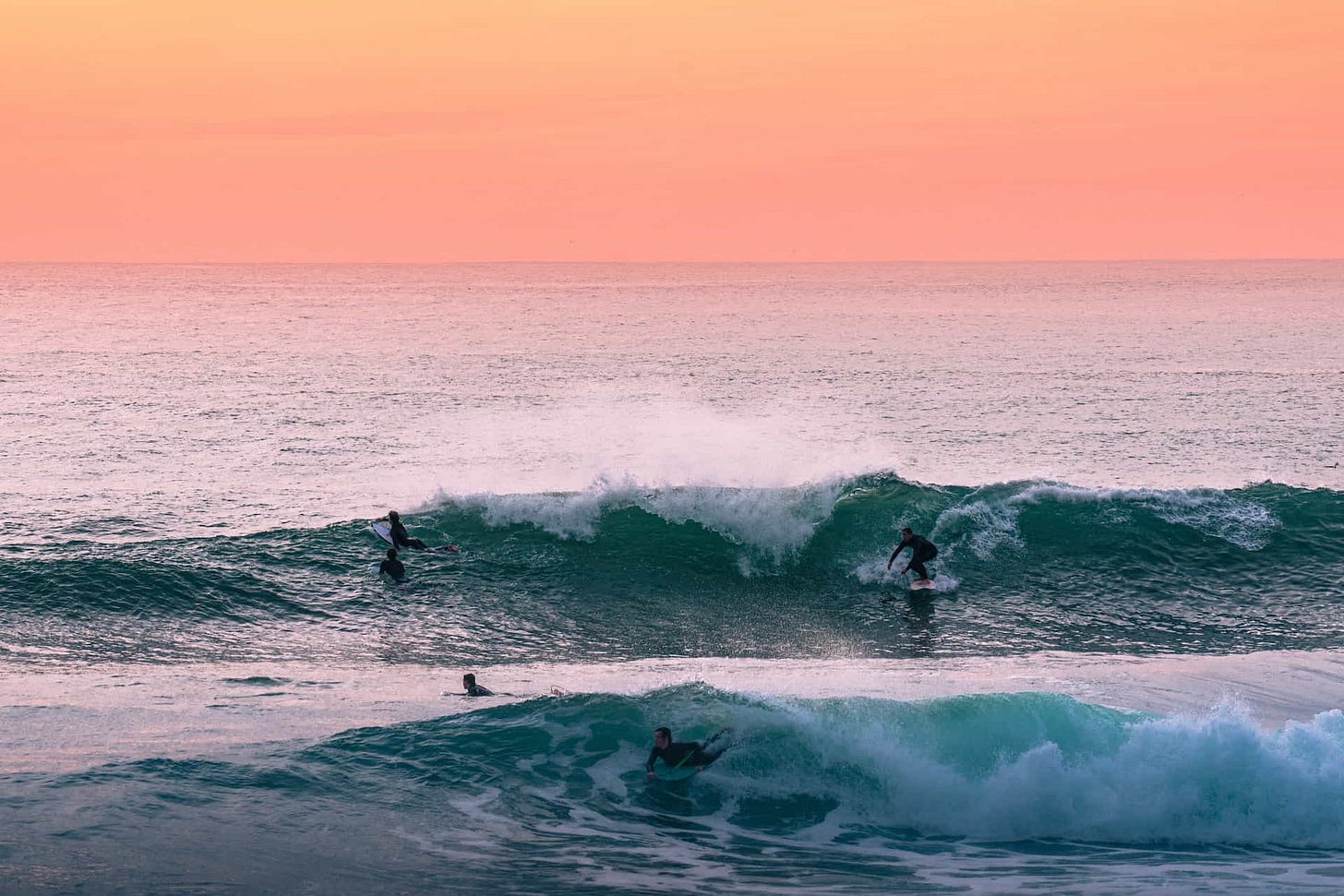 Surfers in Cocoa Beach Riding Waves at Sunrise Surfers in Cocoa Beach Riding Waves at Sunrise