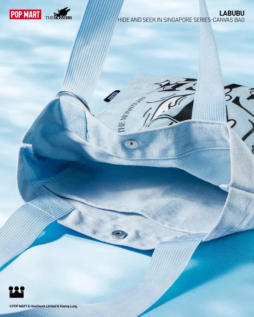 Subject: Labubu Hide and Seek canvas tote bag, interior view with snap closure against water-blue background.
