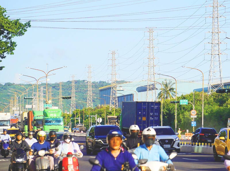 高溫日裡的輸電設施與城市車流|來源:Taipei Times / CNA 高溫日裡的輸電設施與城市車流|來源:Taipei Times / CNA