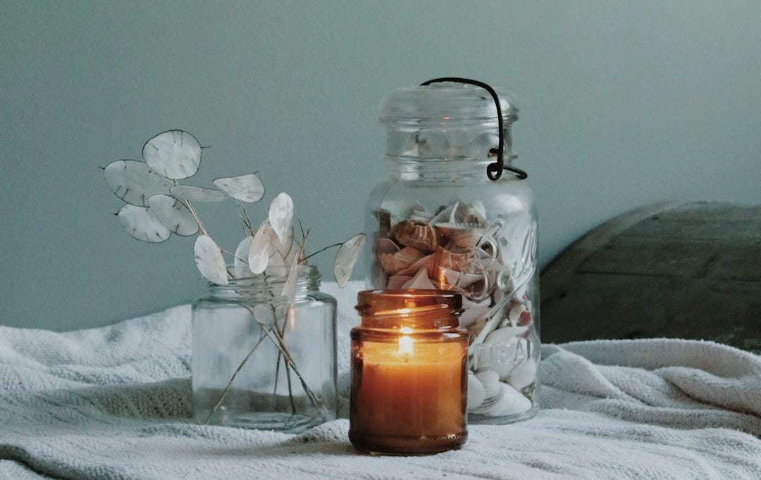 clear glass jar on white floral textile