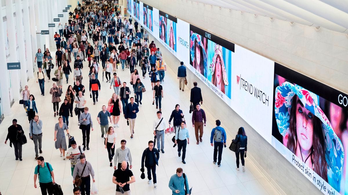 FILE - Commuters walk through a corridor in the World Trade Center Transportation Hub in New York on June 21, 2019. (AP Photo/Mark Lennihan, File)