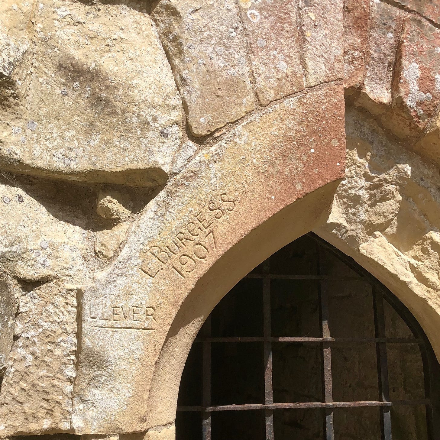 A stone arch with a grate

AI-generated content may be incorrect.