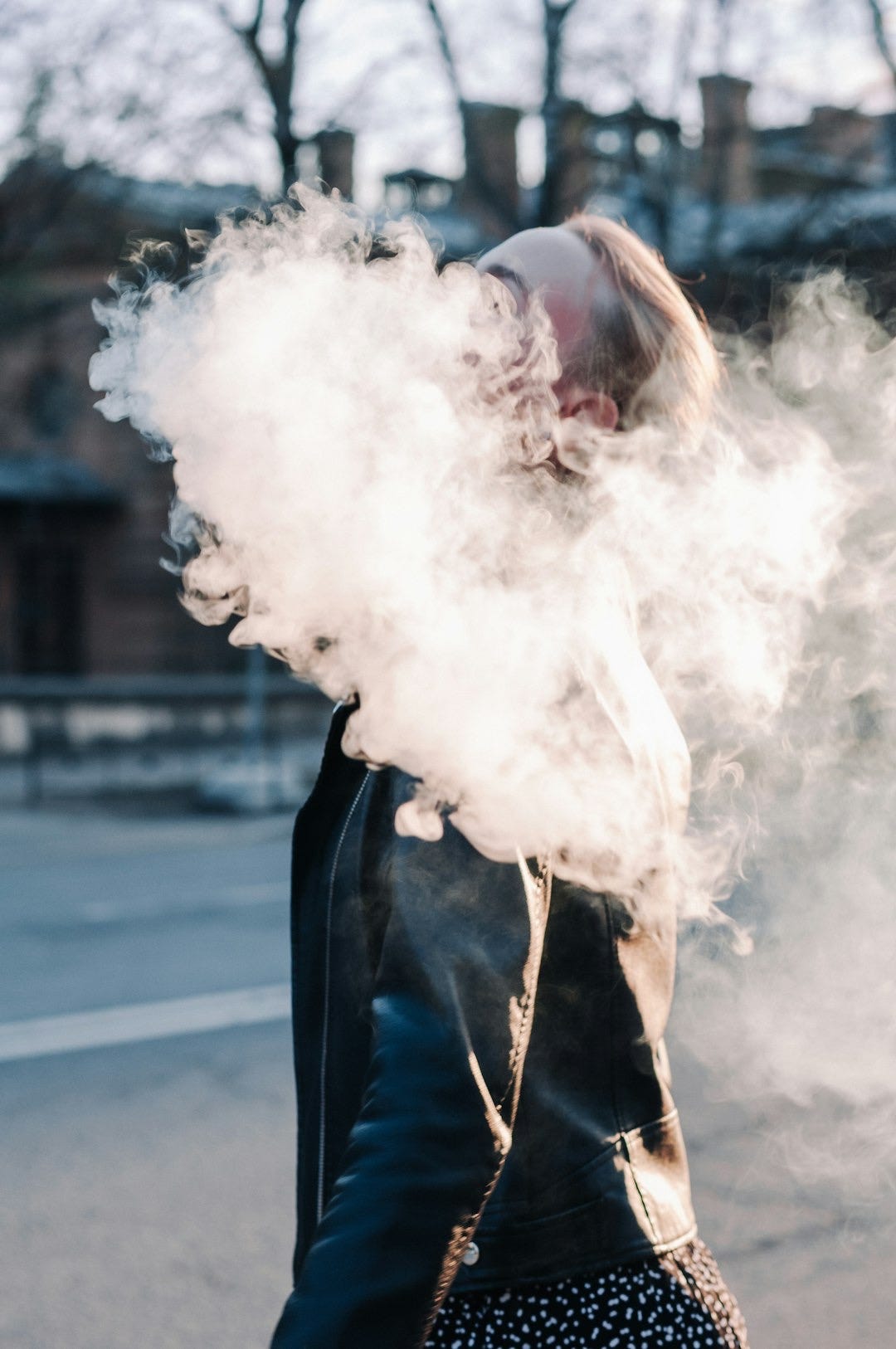 a woman in a black leather jacket smoking a cigarette a woman in a black leather jacket smoking a cigarette