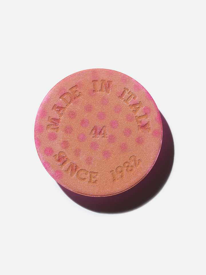 Two images: A terracotta disc and a woman applying blush in a white shirt sitting in a lounge chair by the water.