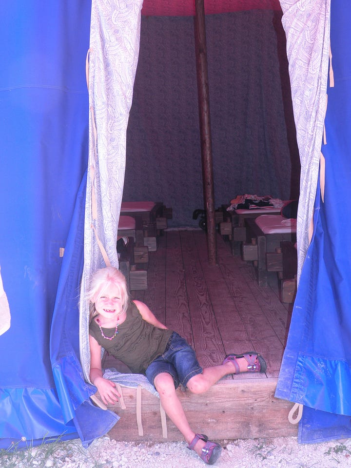 In the first image, a toddler is standing on the beach wearing a bathing suit and wrapped in a towel. In the second photo, a 6-year-old blonde girl is sitting in the opening to a tent.