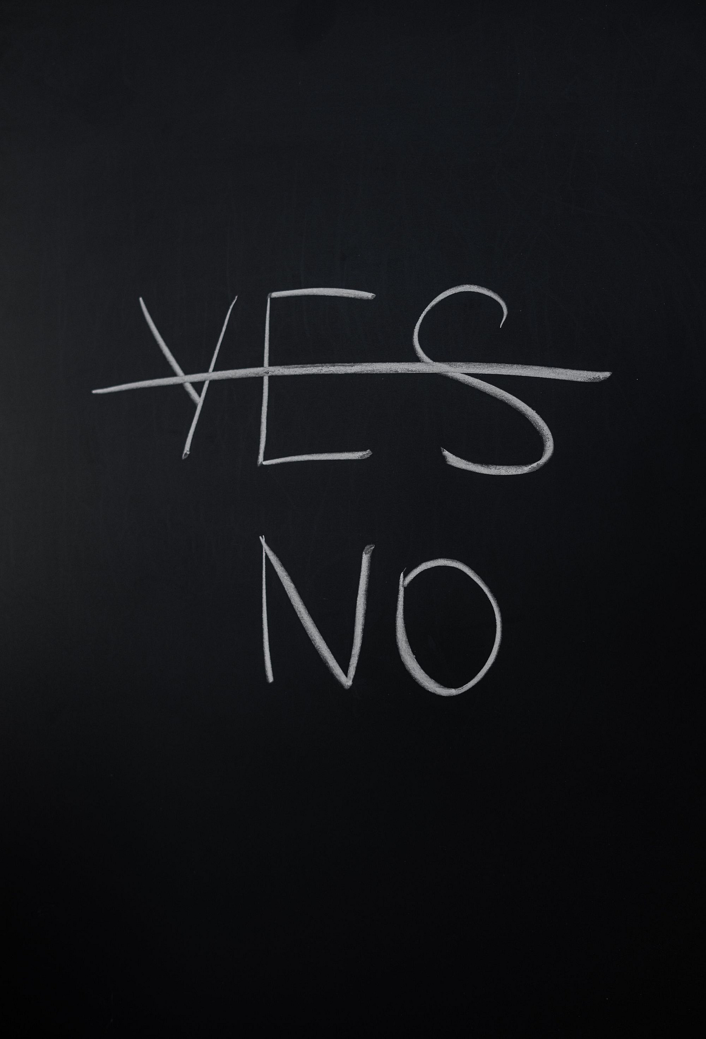 A chalkboard with the word "yes" crossed out and replaced with "no"