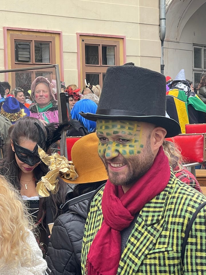 A woman offers cups of svařák (Czech mulled wine) to strangers during the Masopust procession.