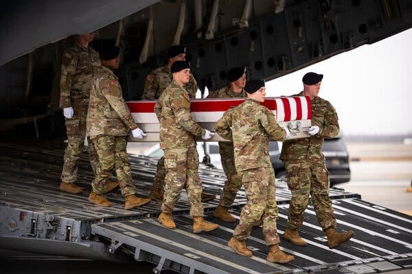 Several U.S. troops carry a flag-draped casket. Several U.S. troops carry a flag-draped casket.