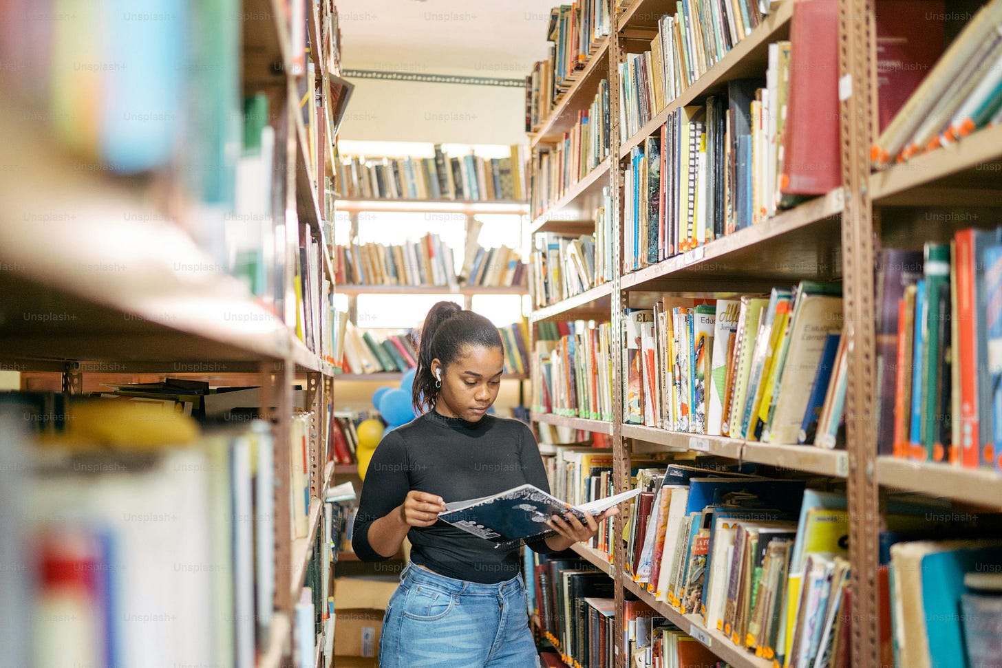 a woman reading a book in a library a woman reading a book in a library
