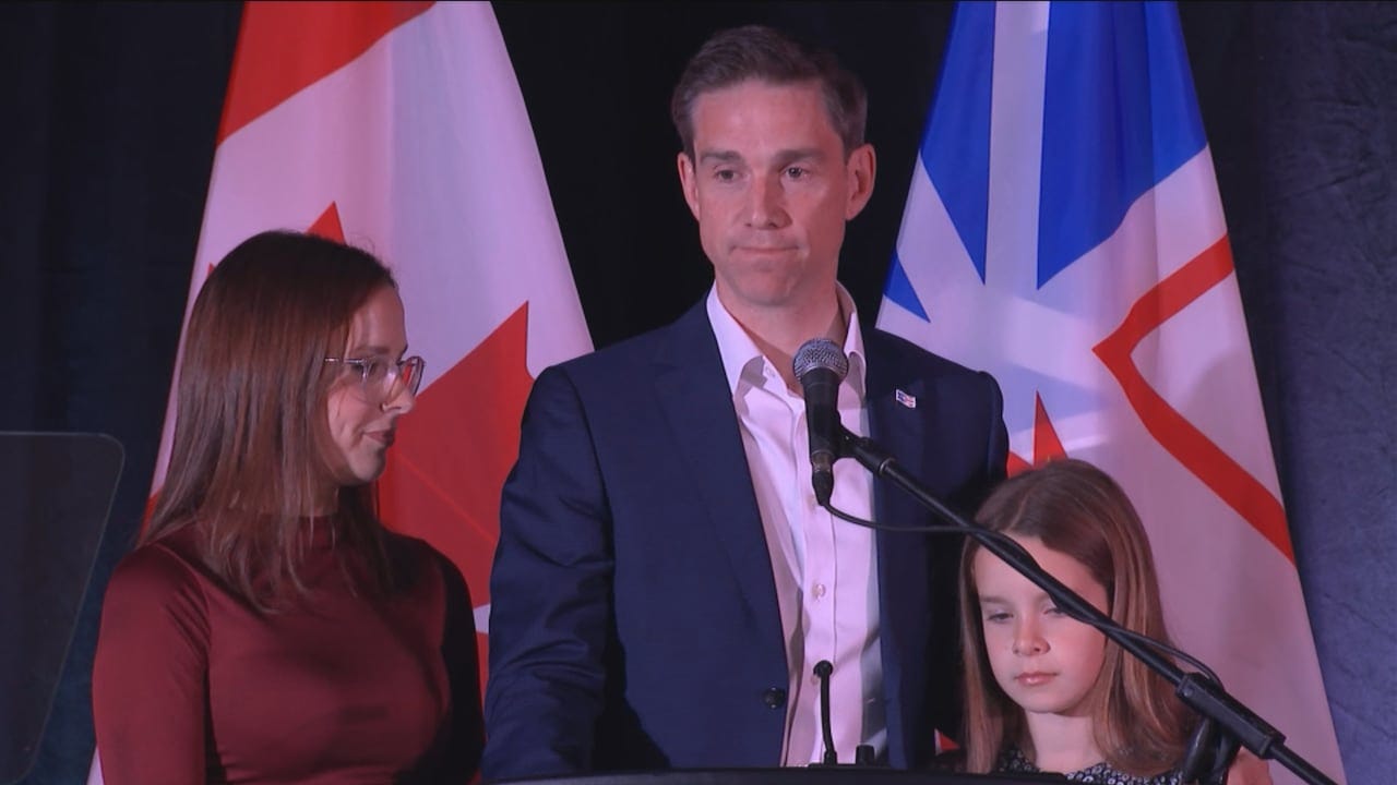 A man at a microphone, flanked by a woman and child.