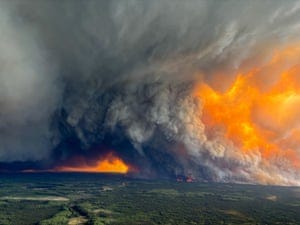 Large fires burn and dense smoke billows up from a wooded landscape Large fires burn and dense smoke billows up from a wooded landscape